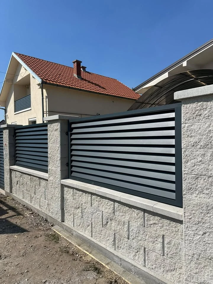 Antracit aluminijumska ograda ugrađena između kamenih stubova